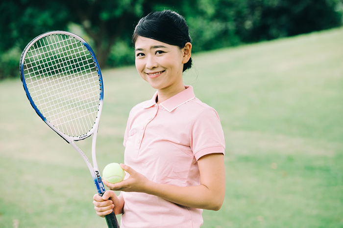 テニスボールとラケットを持つ女性